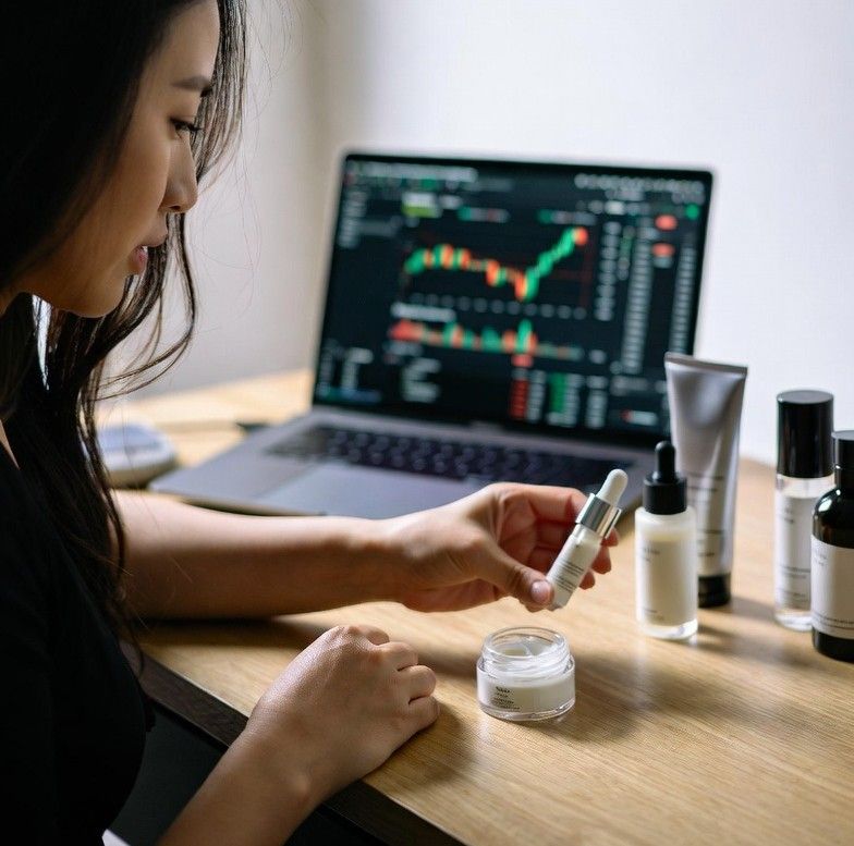 beauty entrepreneur reviewing skincare products and cryptocurrency charts